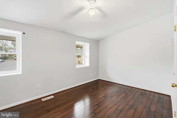 a view of a room with wooden floor and windows