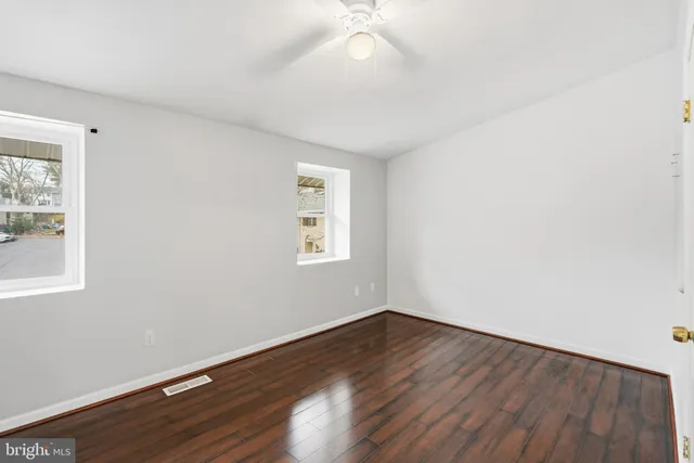a view of a room with wooden floor and windows
