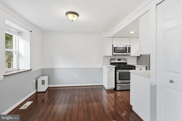 a kitchen with granite countertop a refrigerator and a stove top oven