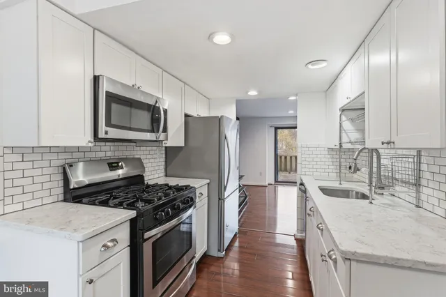 a kitchen with a sink stove top oven and refrigerator