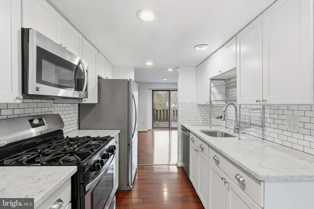 a kitchen with stainless steel appliances a sink stove and cabinets
