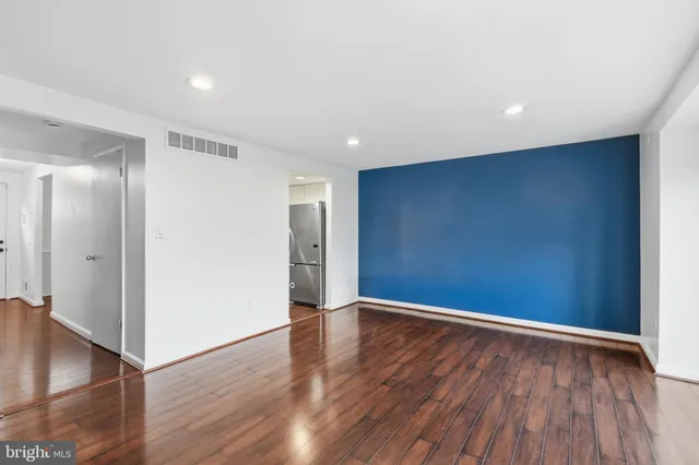 a view of empty room with wooden floor