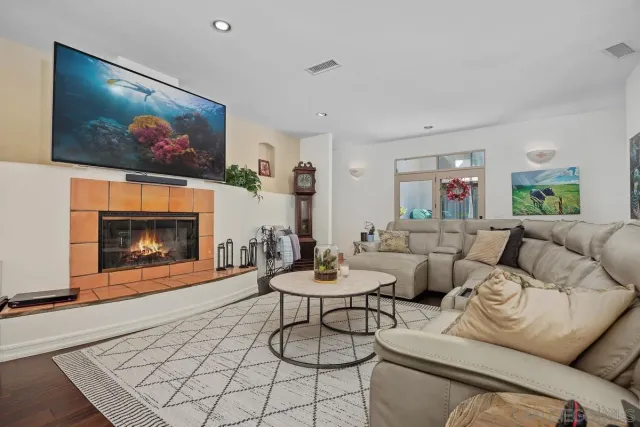 a living room with furniture a flat screen tv and a fireplace