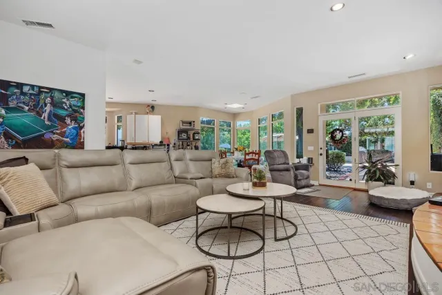 a living room with furniture potted plant and large windows