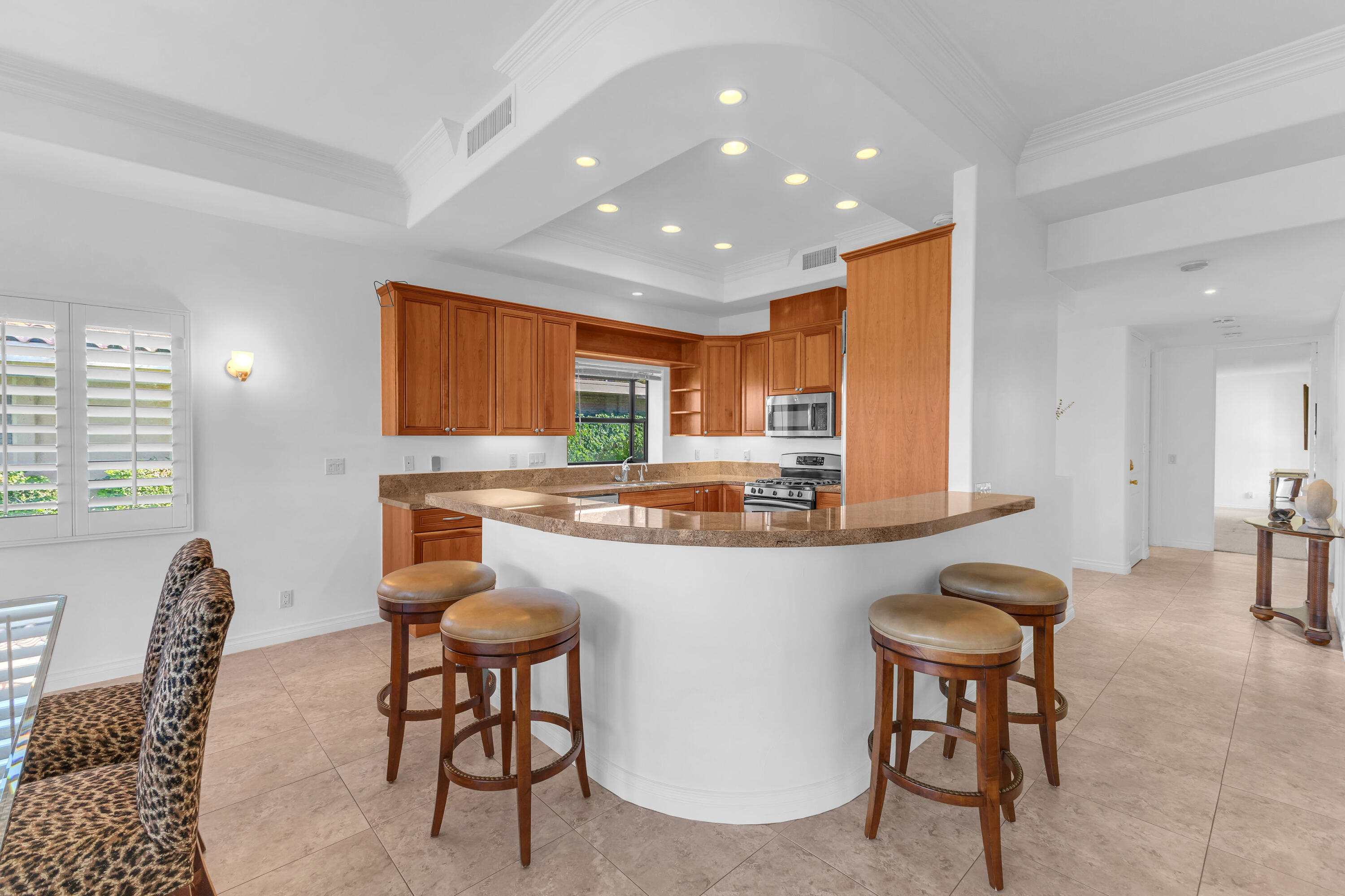 77690 Seminole Road Indian Wells, CA 92210 - Photo 26 of 59 a kitchen with kitchen island granite countertop wooden cabinets and dining table