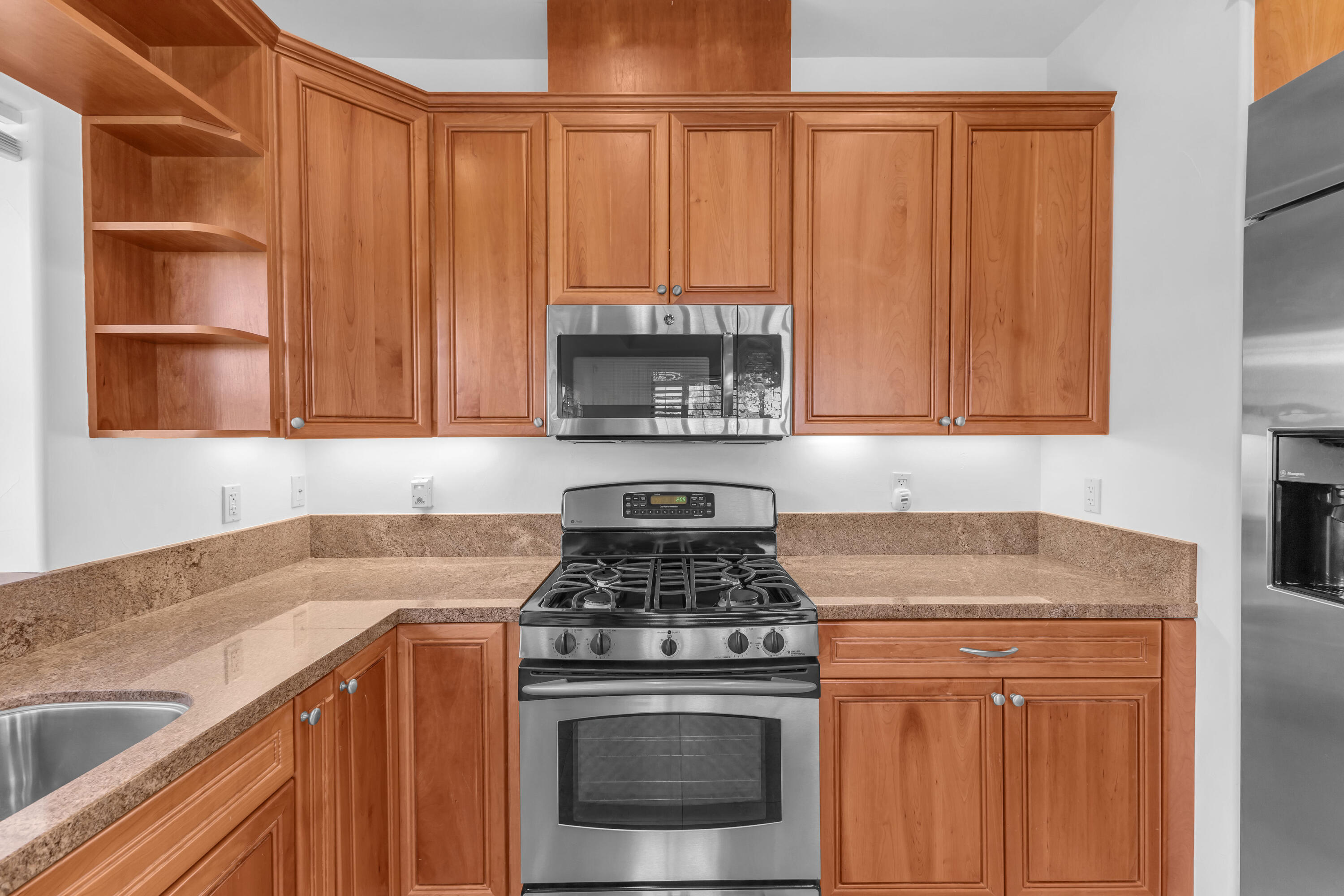 77690 Seminole Road Indian Wells, CA 92210 - Photo 29 of 59 a kitchen with granite countertop wood cabinets stainless steel appliances and a sink