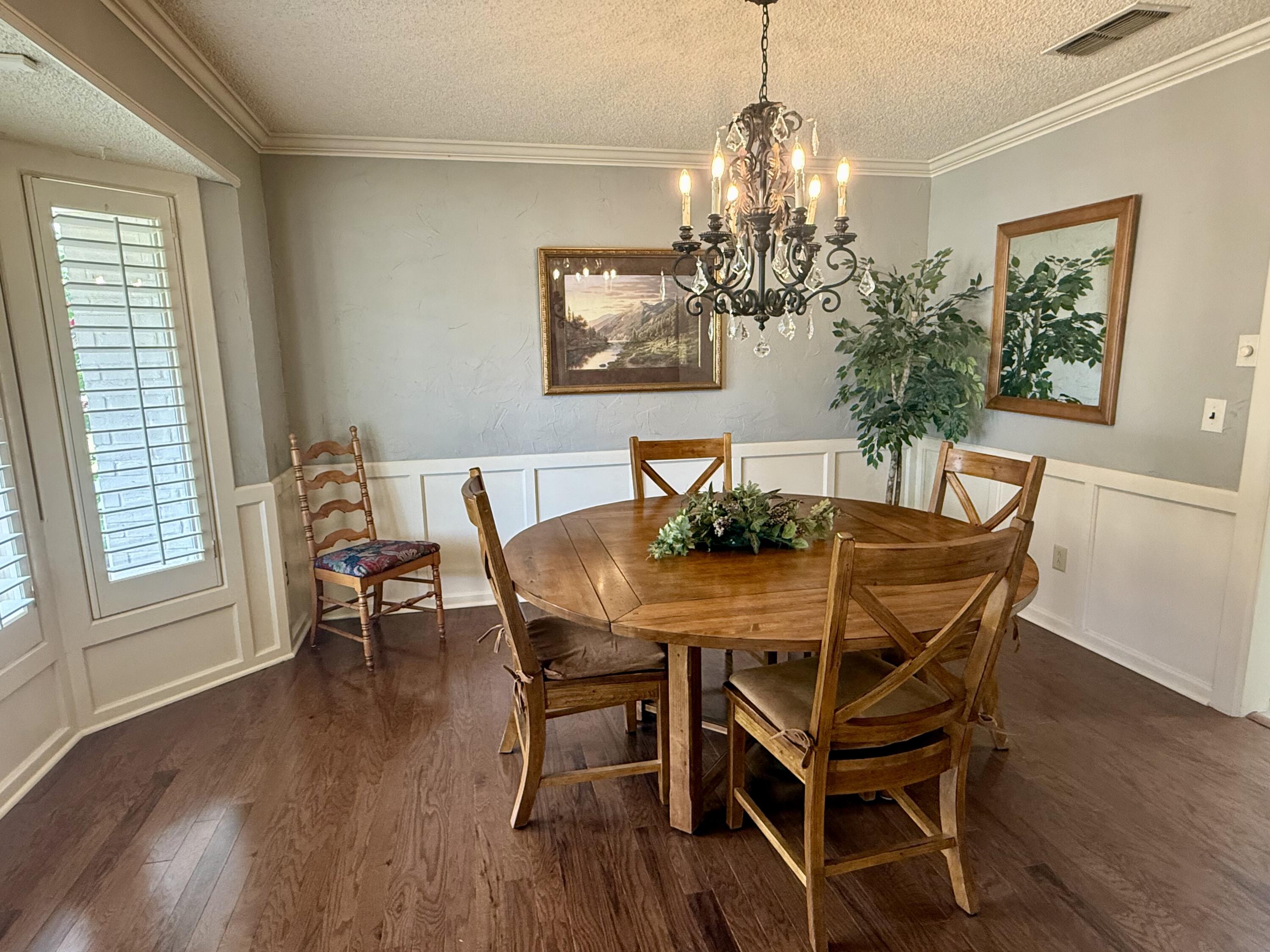 4911 92nd Street Lubbock, TX 79424 - Photo 14 of 77 a dining room with furniture a chandelier and wooden floor