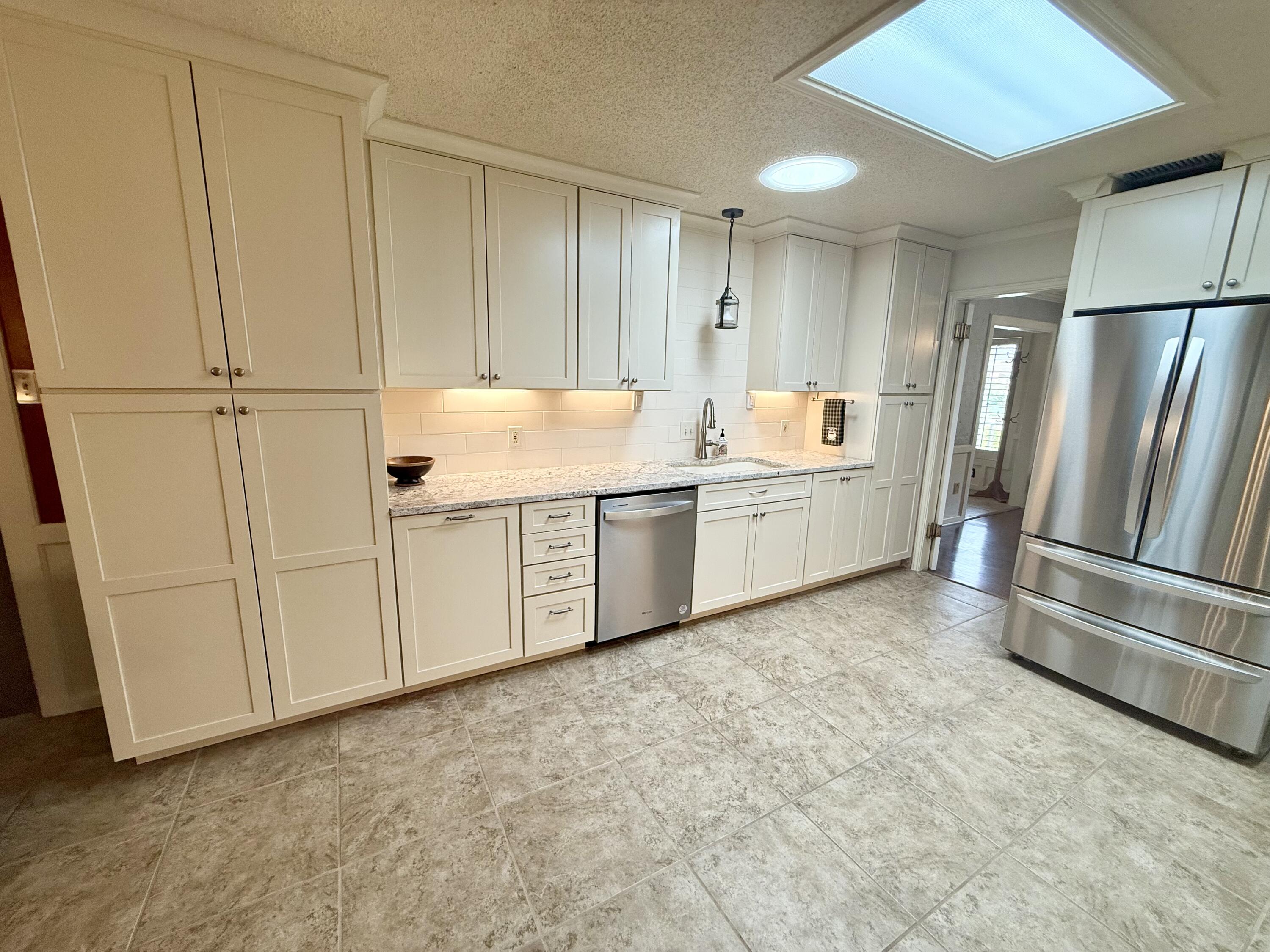 4911 92nd Street Lubbock, TX 79424 - Photo 20 of 77 a kitchen with stainless steel appliances granite countertop a refrigerator a stove and a sink