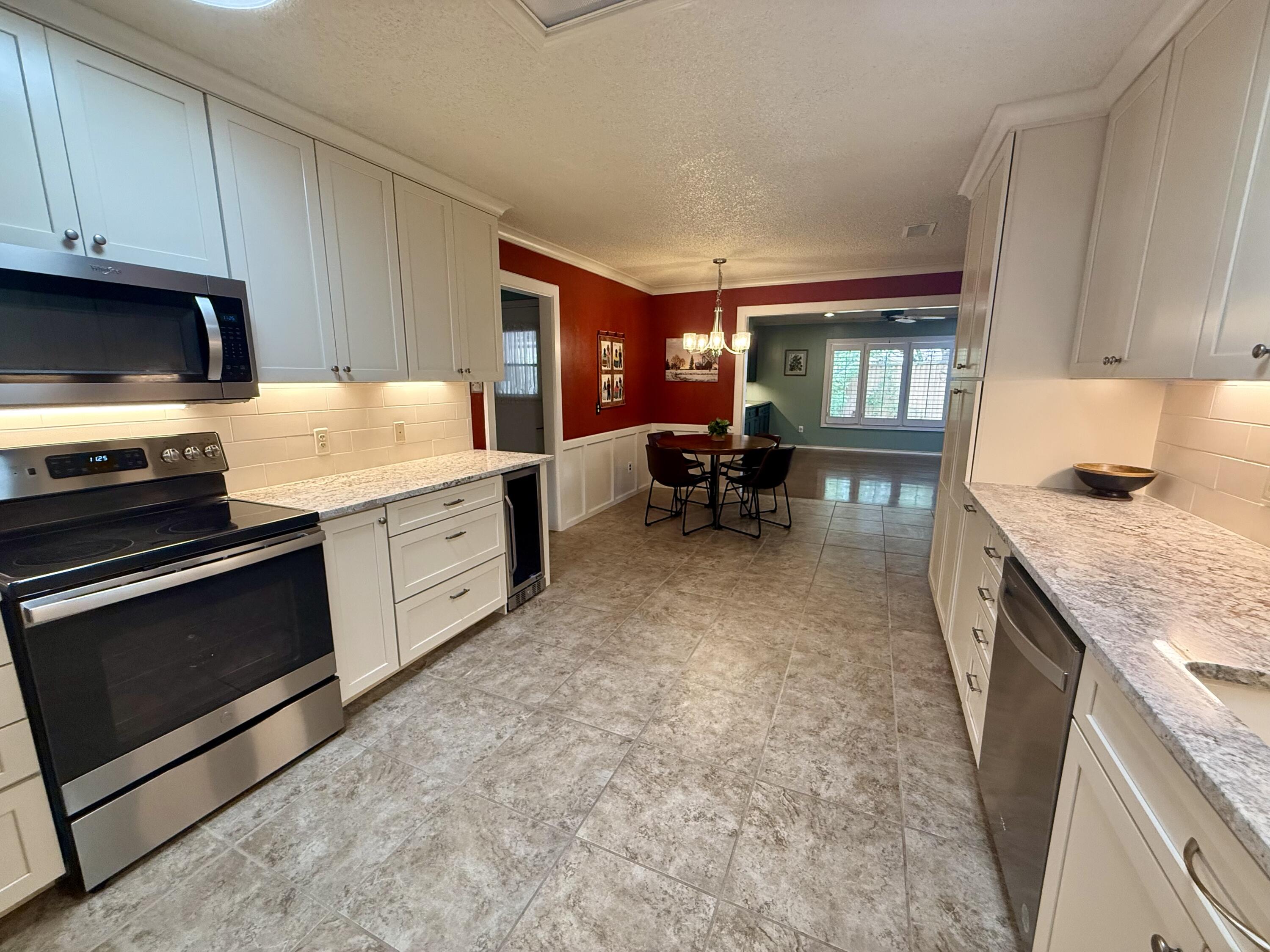 4911 92nd Street Lubbock, TX 79424 - Photo 27 of 77 a kitchen with sink cabinets and stove top oven