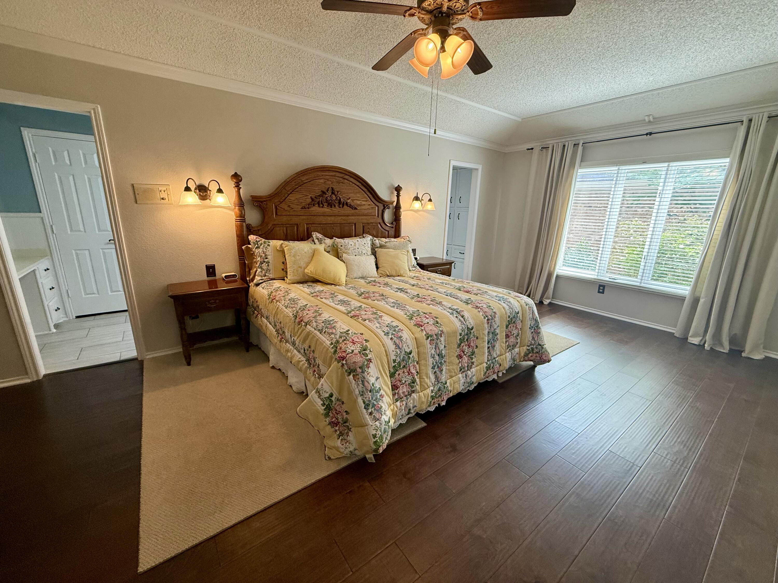 4911 92nd Street Lubbock, TX 79424 - Photo 41 of 77 a bedroom with a bed and a chandelier