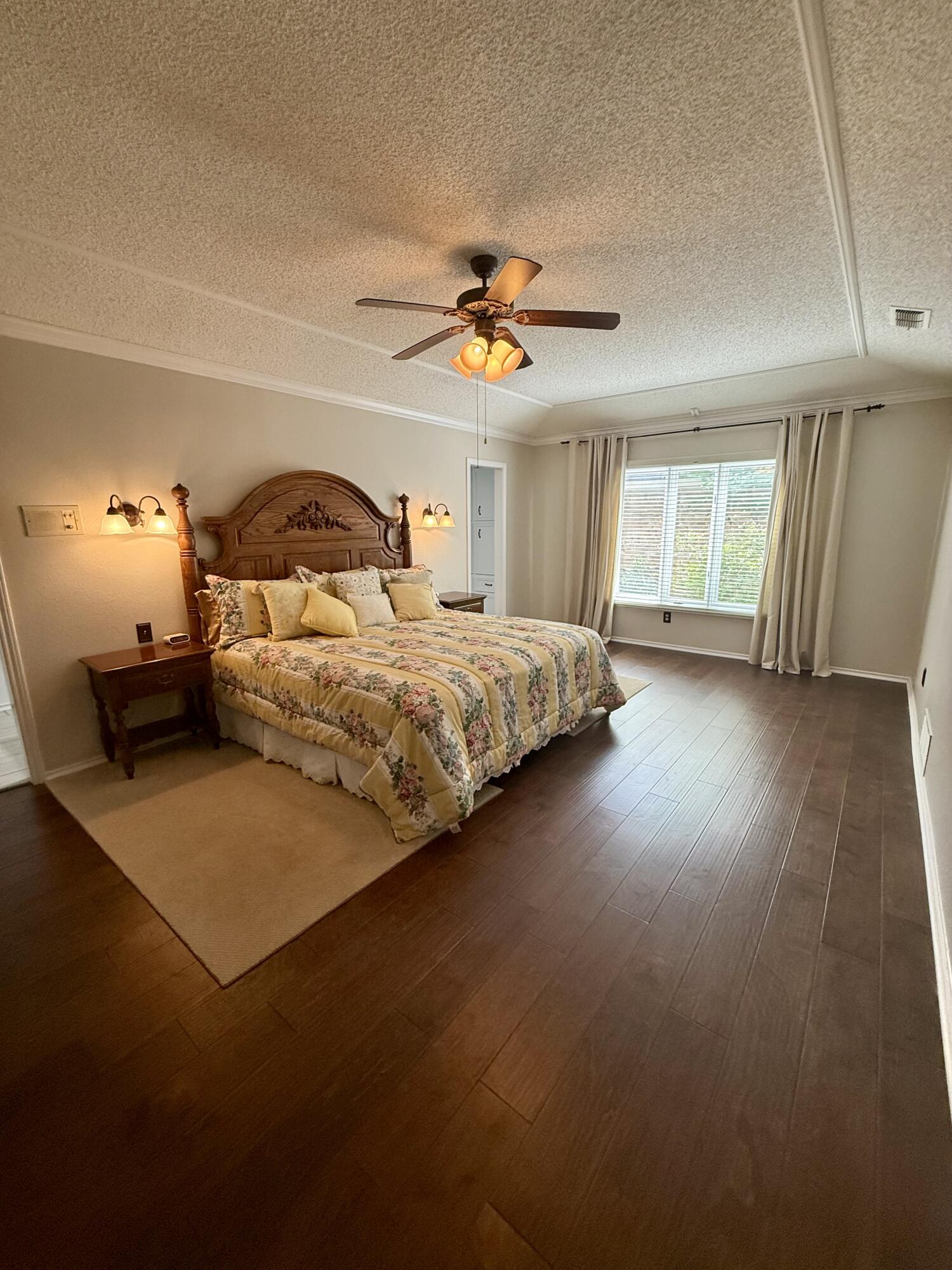 4911 92nd Street Lubbock, TX 79424 - Photo 42 of 77 a bedroom with a bed and a chandelier