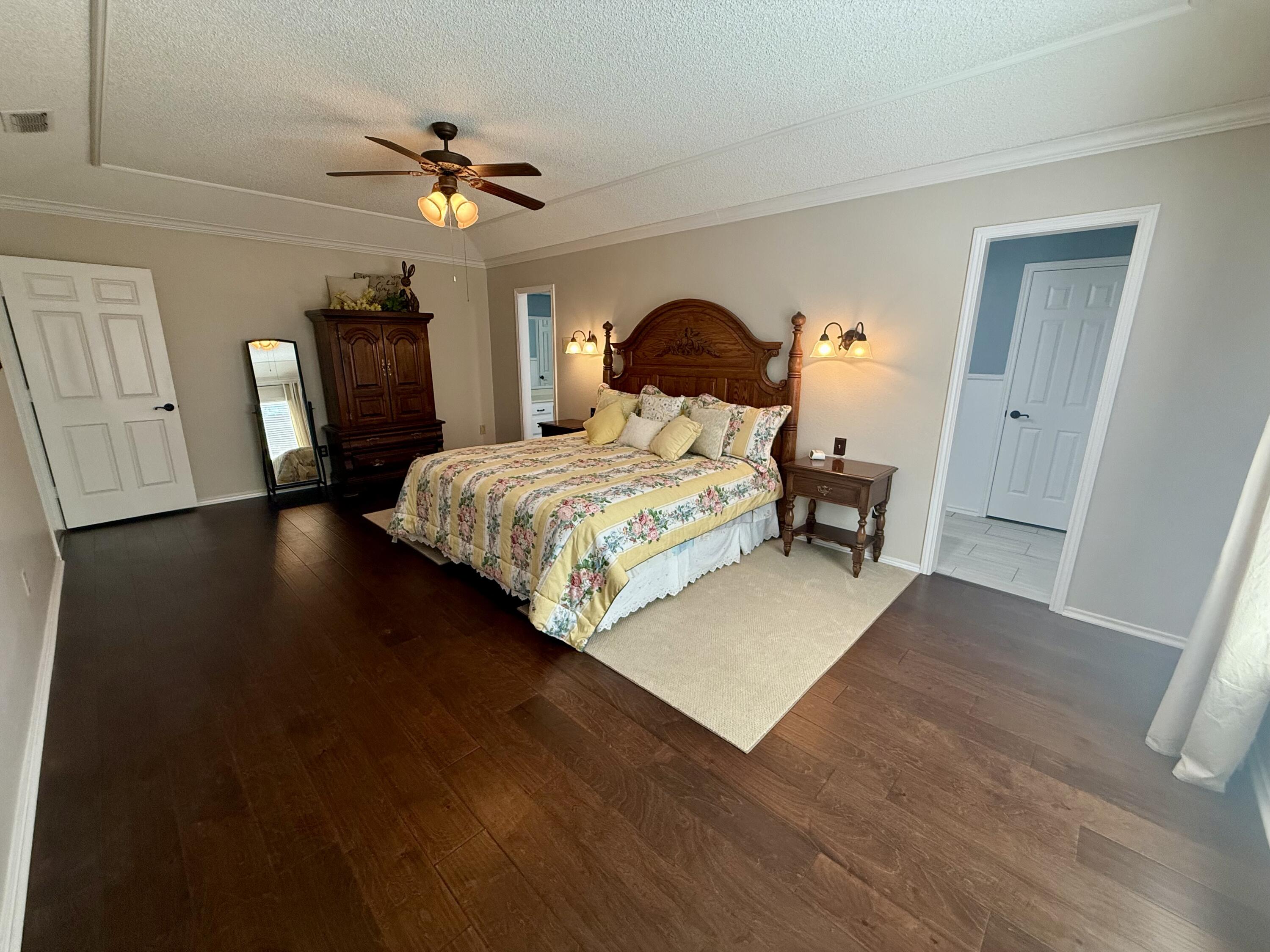 4911 92nd Street Lubbock, TX 79424 - Photo 52 of 77 a bedroom with a bed and wooden floor