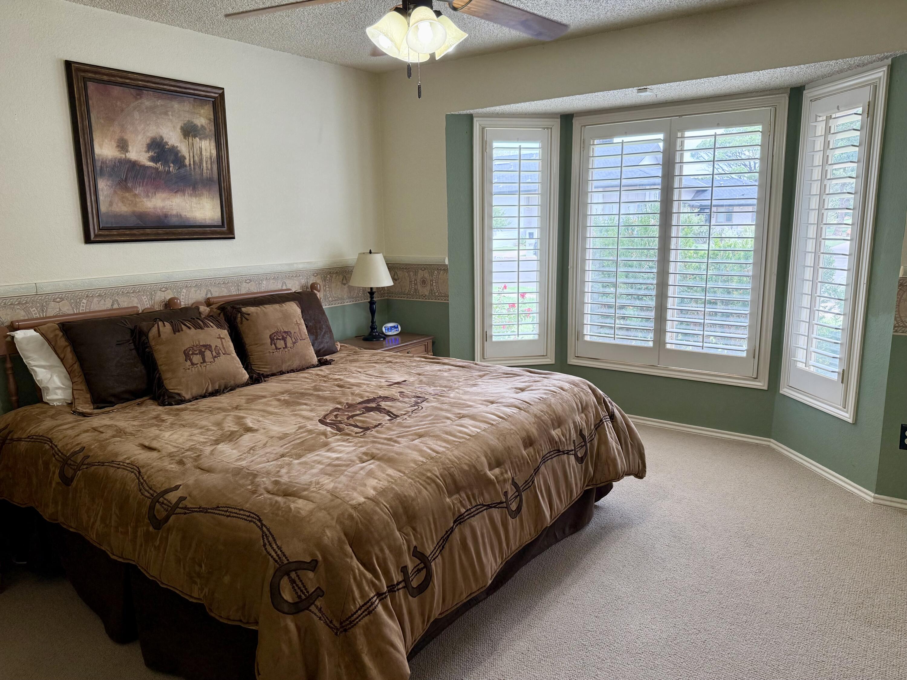 4911 92nd Street Lubbock, TX 79424 - Photo 56 of 77 a large bed sitting in a bedroom next to a window