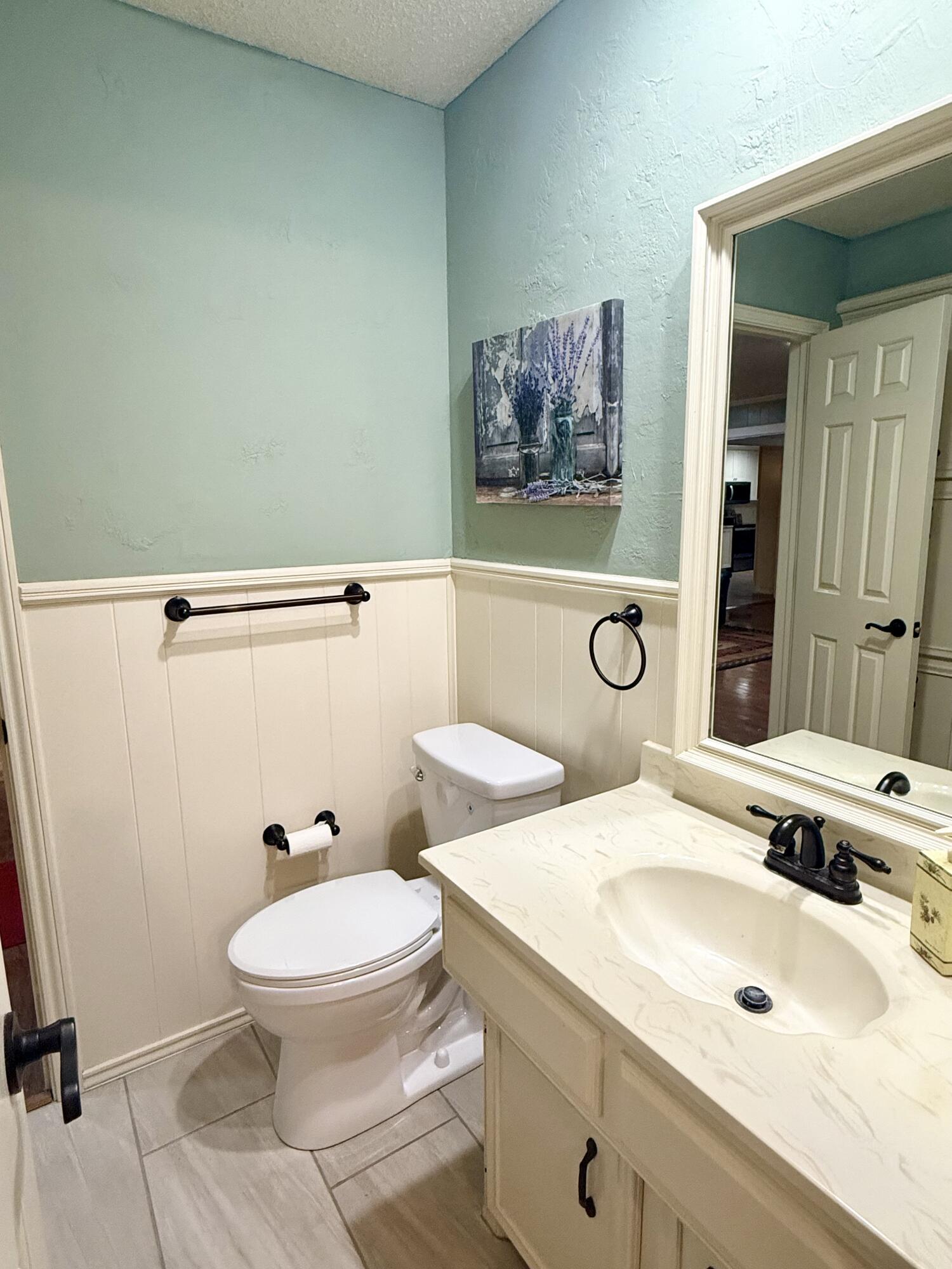 4911 92nd Street Lubbock, TX 79424 - Photo 67 of 77 a bathroom with a toilet sink and mirror