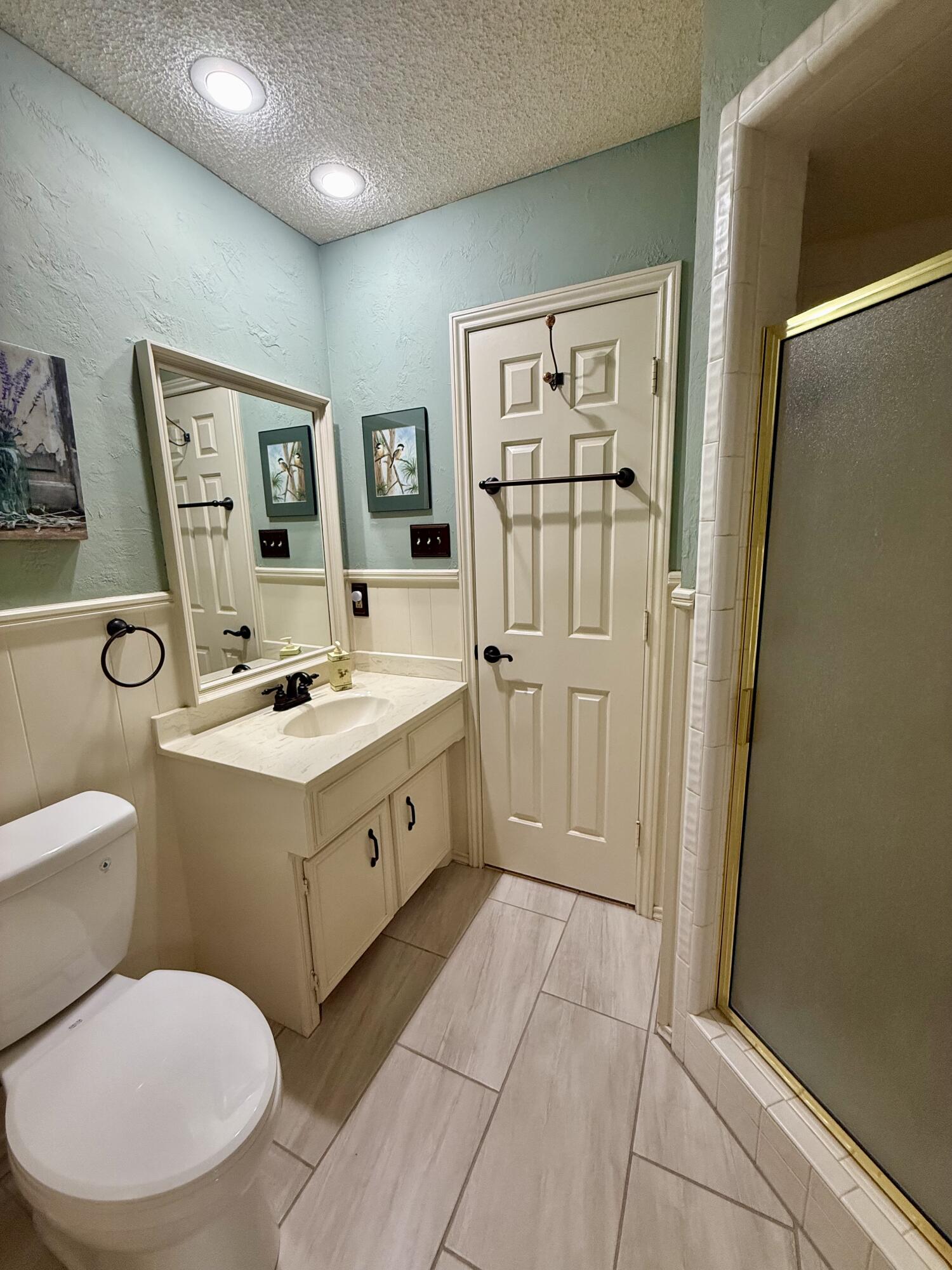 4911 92nd Street Lubbock, TX 79424 - Photo 68 of 77 a spacious bathroom with a toilet sink and mirror