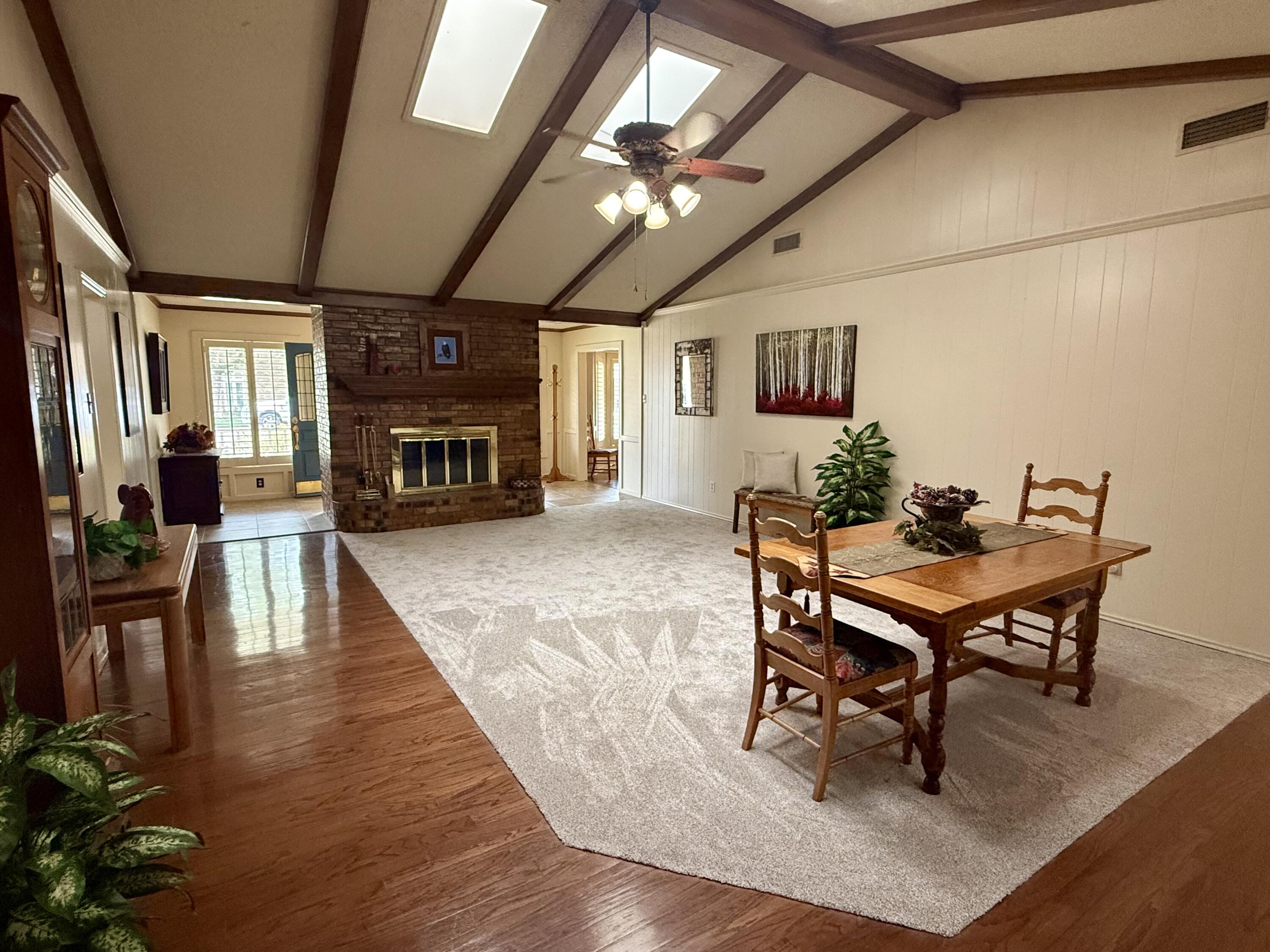 4911 92nd Street Lubbock, TX 79424 - Photo 10 of 77 a dining room with furniture a fireplace and wooden floor