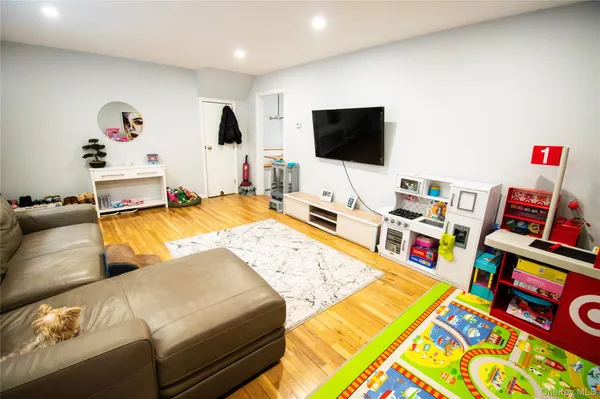 a living room with computer on a bed and a flat screen tv