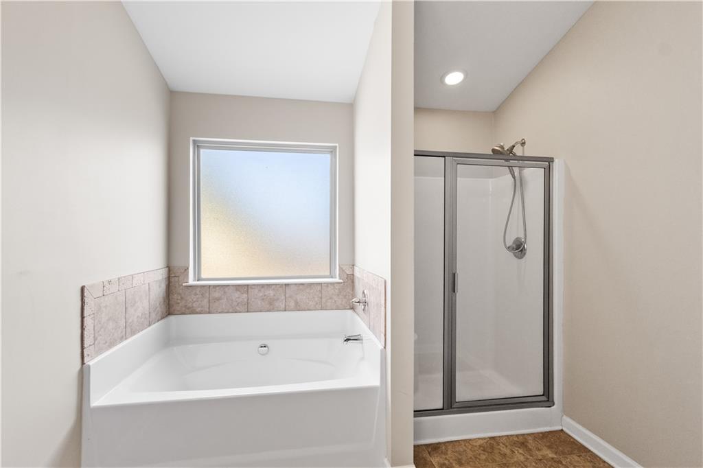 9116 Alden Drive Locust Grove, GA 30248 - Photo 20 of 27 a bathroom with a bathtub and a shower