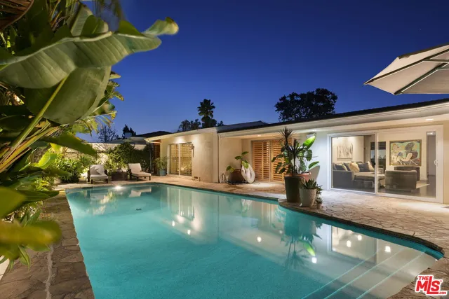 a view of a house with pool and sitting area