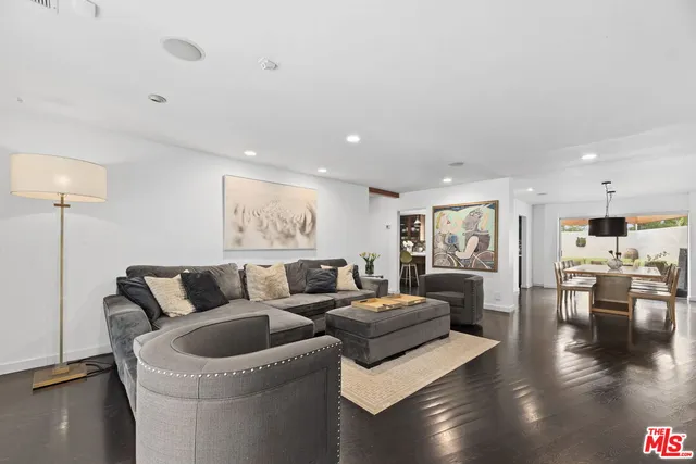 a view of a hallway with wooden floor and a living room