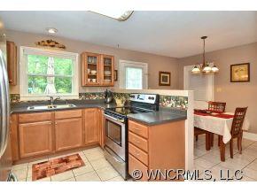 171 Vision Road Canton, NC 28716 - Photo 4 of 17 a kitchen with stainless steel appliances granite countertop a stove top oven a sink a counter space and living room view