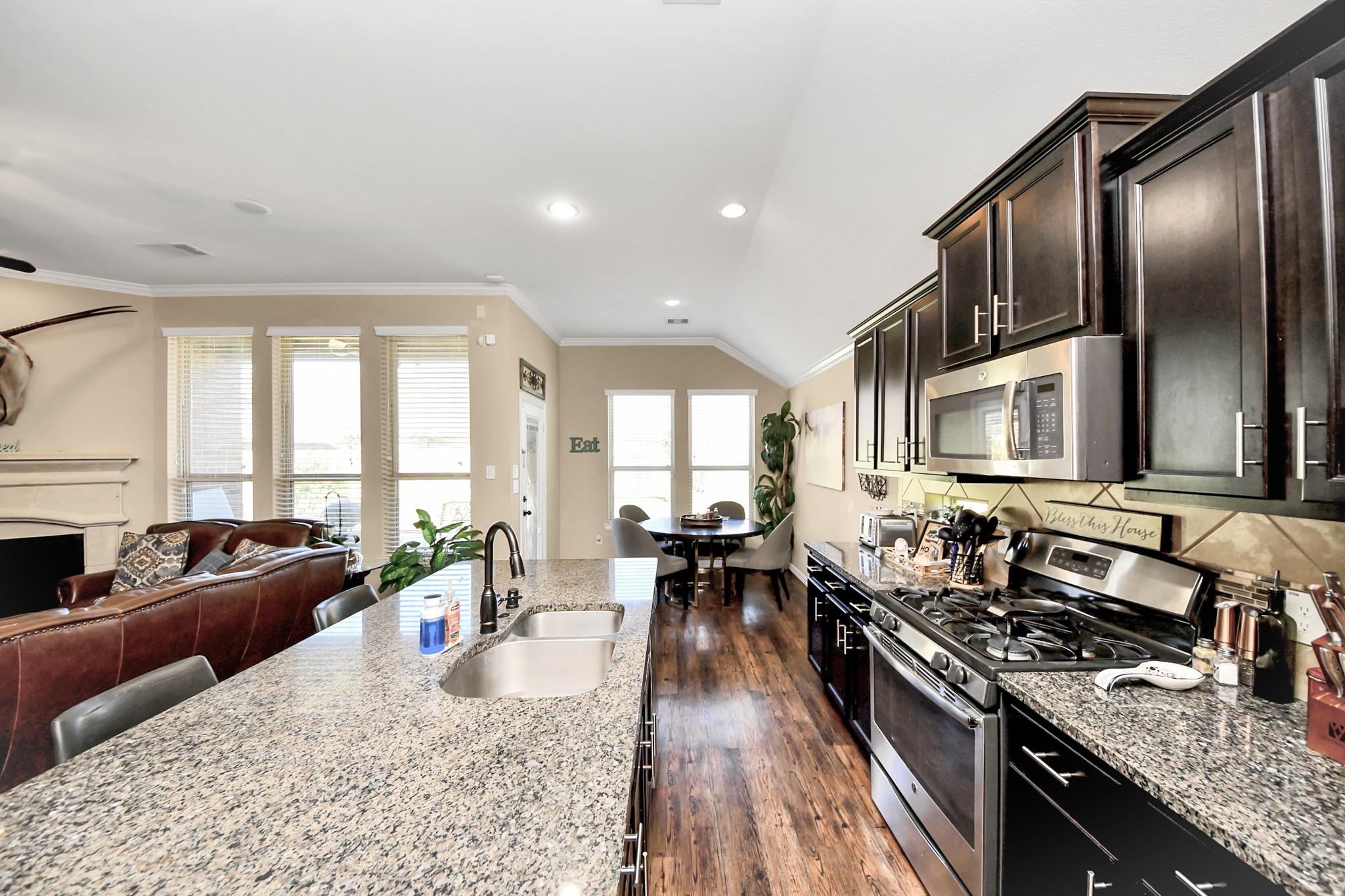 7502 Simpson Springs Lane Spring, TX 77389 - Photo 27 of 38 a living room with stainless steel appliances granite countertop a stove a sink dishwasher a couches and chairs with wooden floor