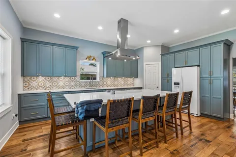 a kitchen with stainless steel appliances kitchen island granite countertop a table and chairs