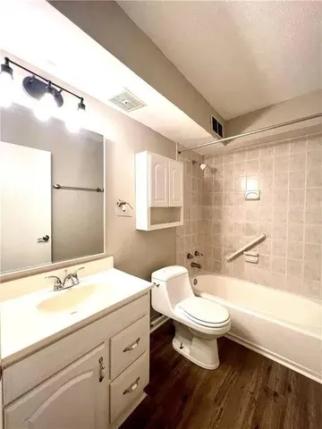 a bathroom with a sink a toilet a mirror and shower