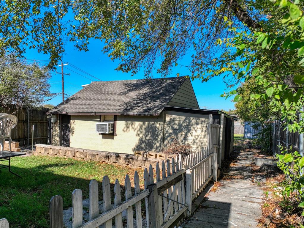2222 Houston Street Grand Prairie, TX 75050 - Photo 21 of 24 a view of a house with a small yard and wooden fence