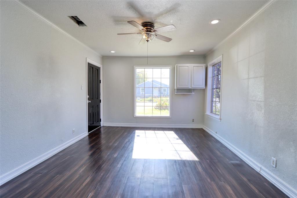 2222 Houston Street Grand Prairie, TX 75050 - Photo 7 of 24 a view of an empty room with a window and wooden floor