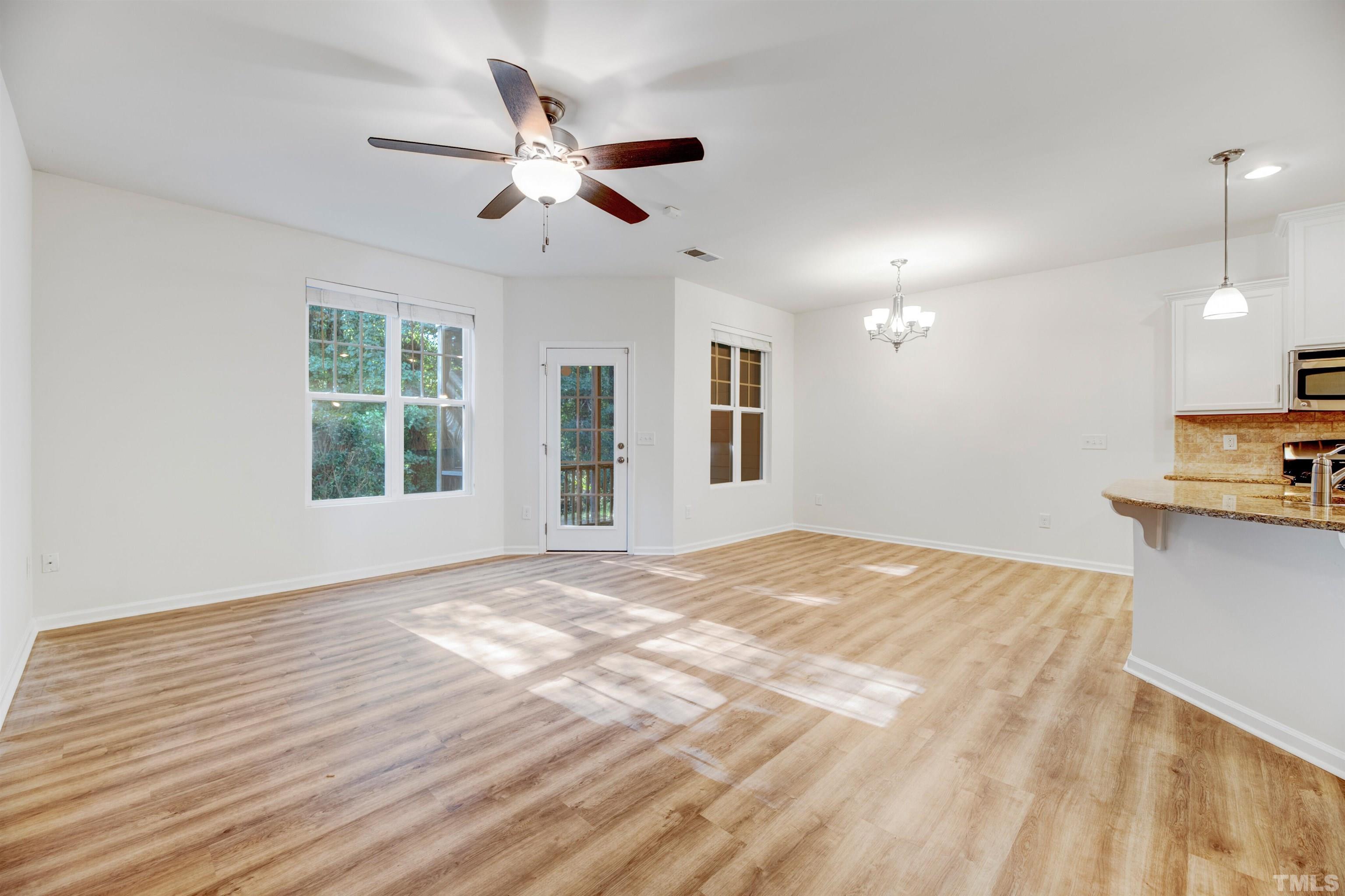 714 Treviso Lane Apex, NC 27502 - Photo 17 of 41 a view of an empty room with window and wooden floor