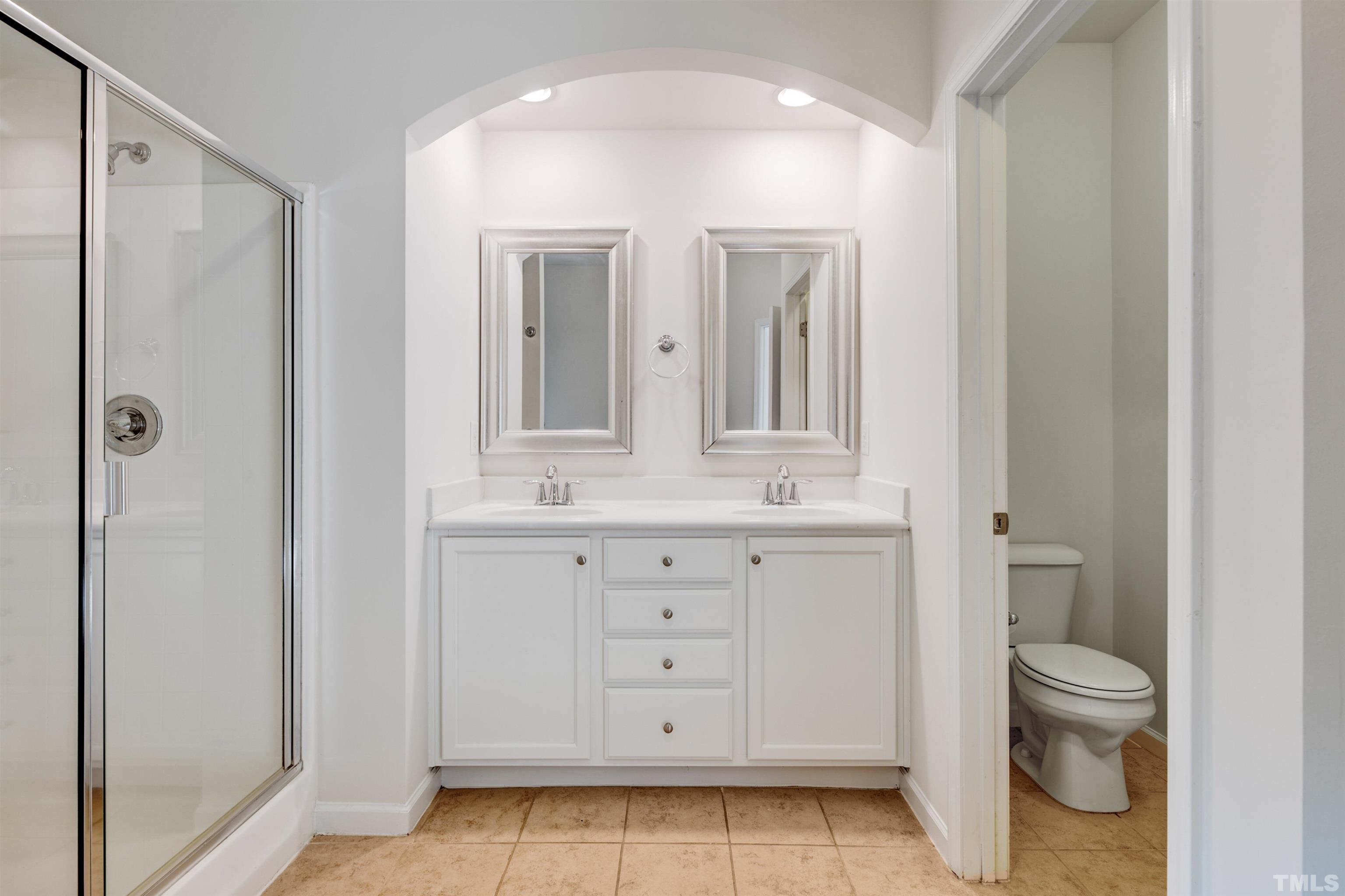 714 Treviso Lane Apex, NC 27502 - Photo 32 of 41 a bathroom with a toilet a sink a vanity and mirror