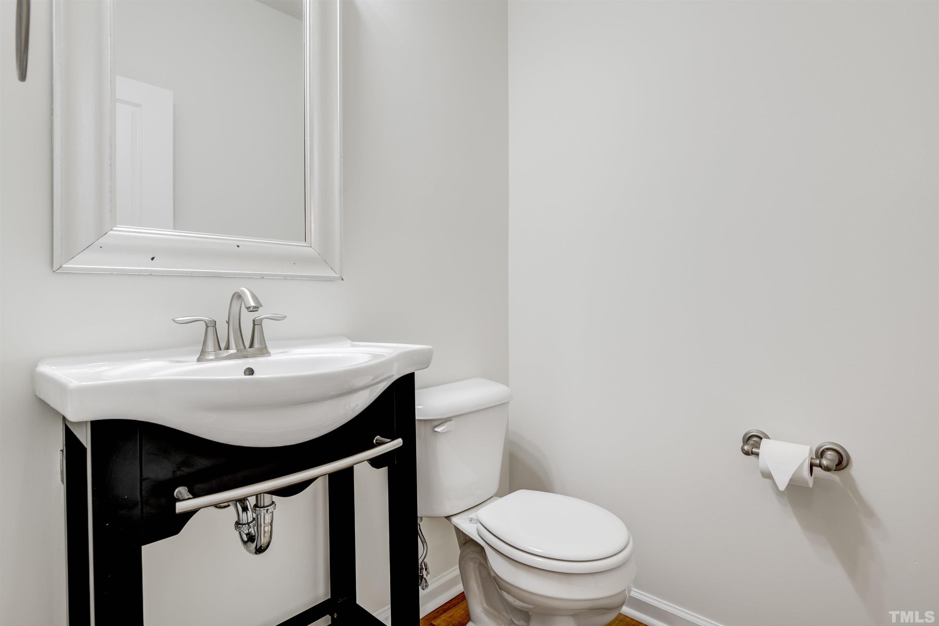 714 Treviso Lane Apex, NC 27502 - Photo 7 of 41 a bathroom with a sink a toilet and a mirror