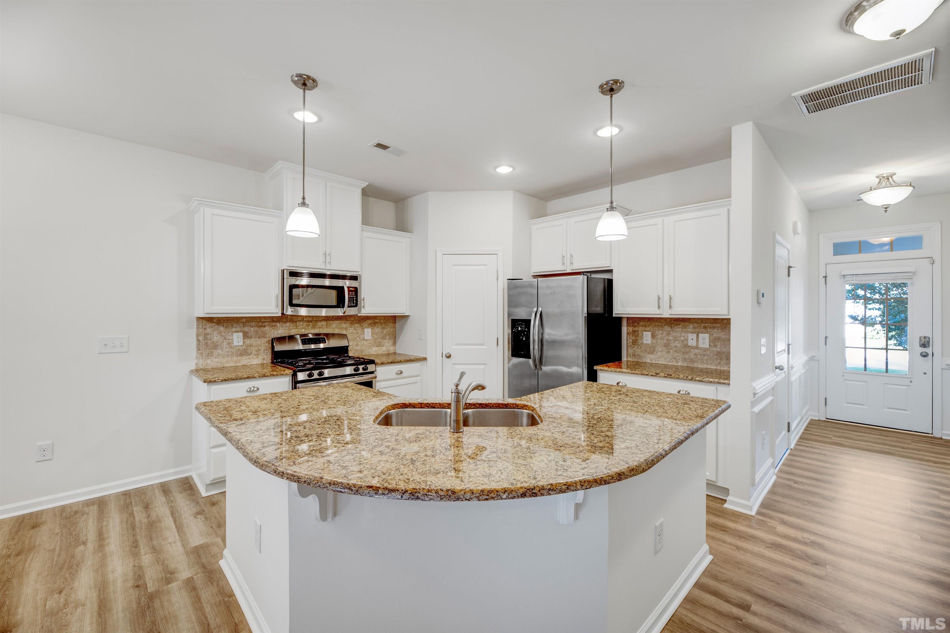 714 Treviso Lane Apex, NC 27502 - Photo 8 of 41 a kitchen with stainless steel appliances granite countertop a sink a refrigerator and a stove