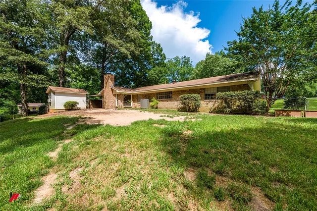 a view of a house with backyard and sitting area