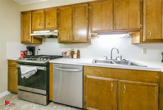 a kitchen with stainless steel appliances granite countertop a sink stove and cabinets