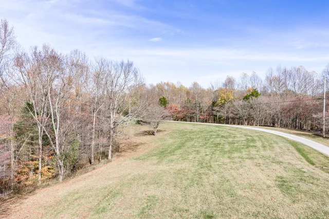 a view of a yard with trees in front of the house