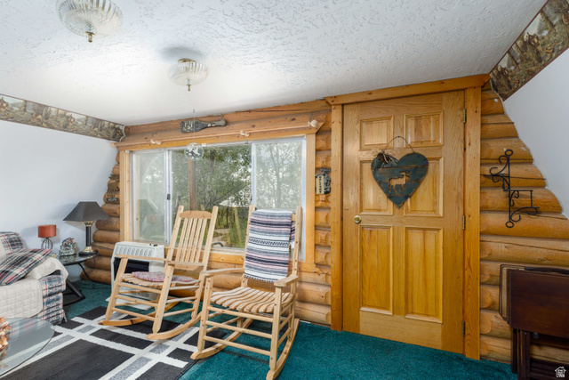 23 Scare Canyon, Unit 23 Logan, UT 84321 - Photo 8 of 33 Interior space featuring log walls, a paneled wood door, and a large sliding window