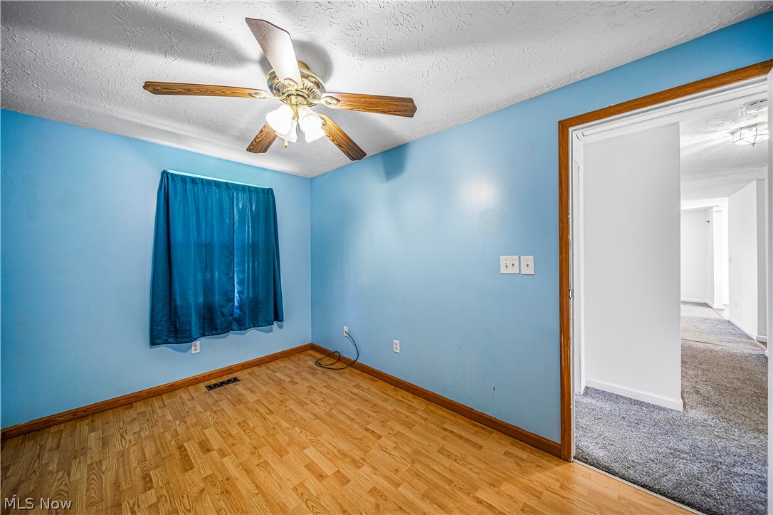 1781 Falkirk Road Madison, OH 44057 - Photo 14 of 25 Empty room featuring light colored carpet, a textured ceiling, and ceiling fan