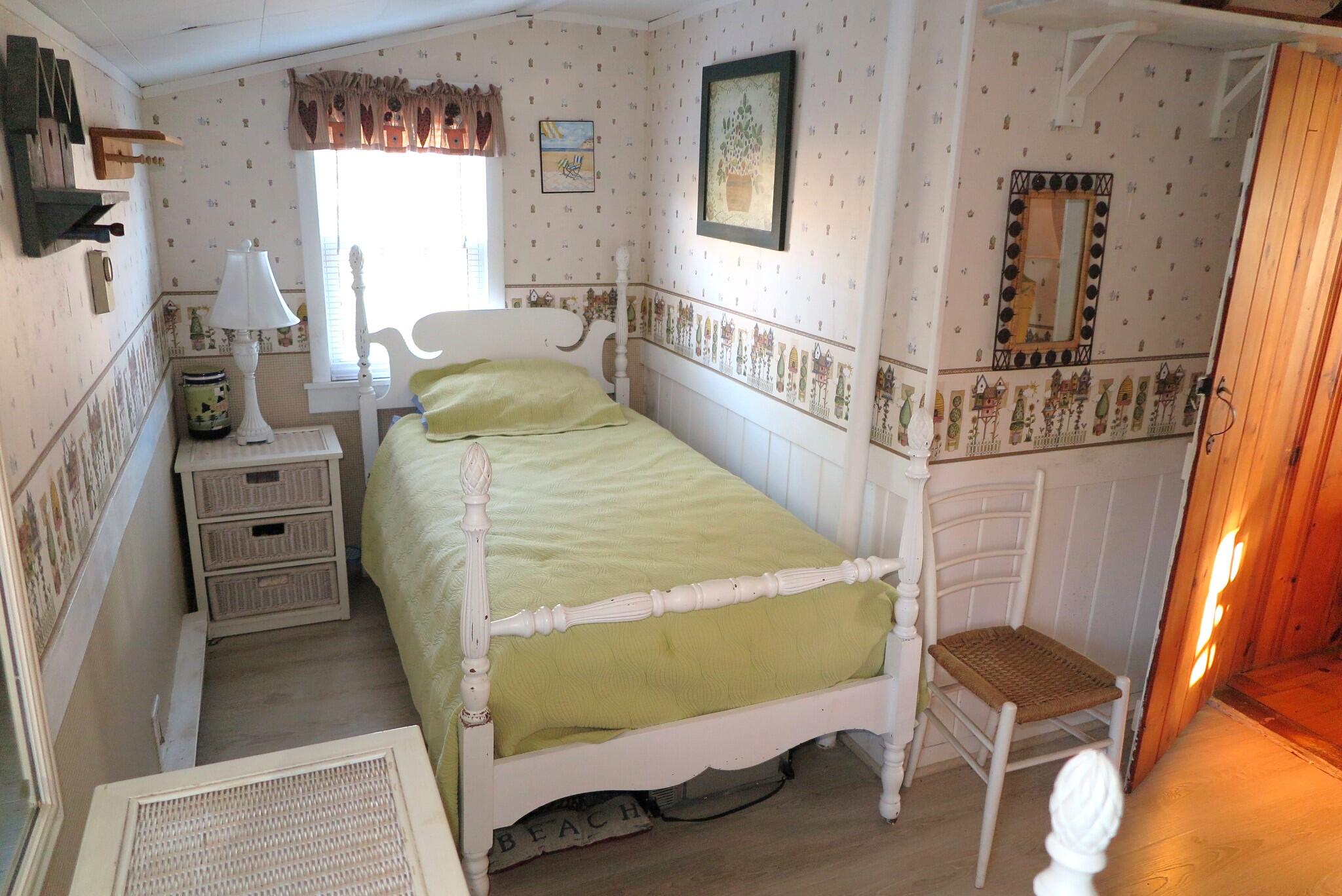 50 Lower County Road Dennis Port, MA 02639 - Photo 13 of 28 a bed sitting in a bedroom next to a window