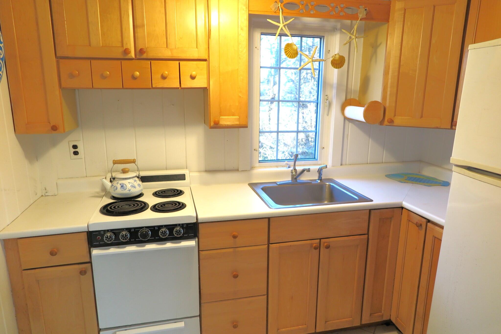 50 Lower County Road Dennis Port, MA 02639 - Photo 7 of 28 a kitchen with a sink stove and cabinets