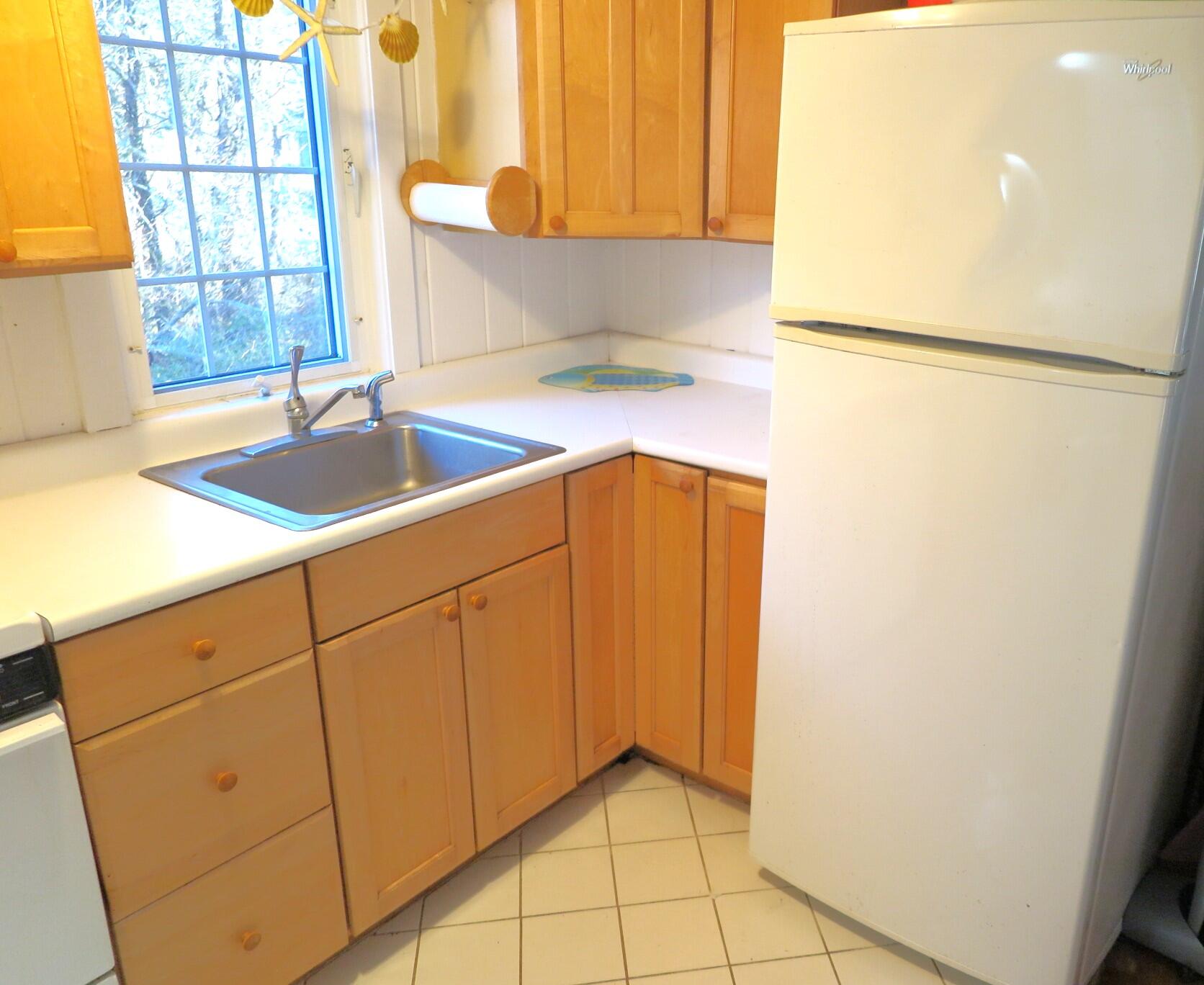 50 Lower County Road Dennis Port, MA 02639 - Photo 8 of 28 a kitchen with a sink and a refrigerator