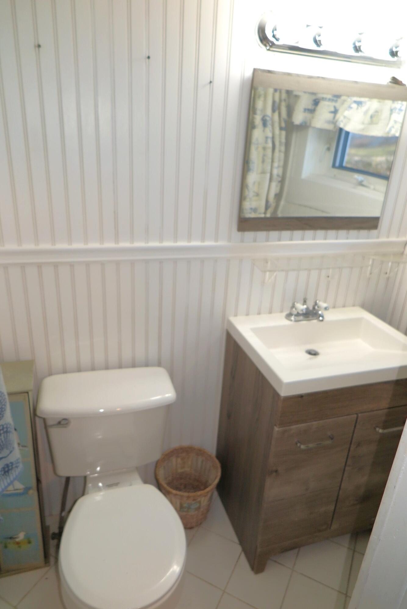 50 Lower County Road Dennis Port, MA 02639 - Photo 9 of 28 a white toilet sitting next to a bathroom sink