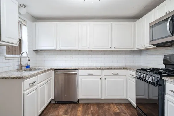 a kitchen with white cabinets and white appliances