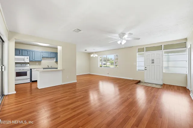 a kitchen with stainless steel appliances a refrigerator and wooden floor