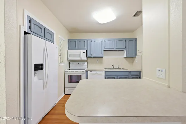 a view of a room with wooden floor and a bathroom