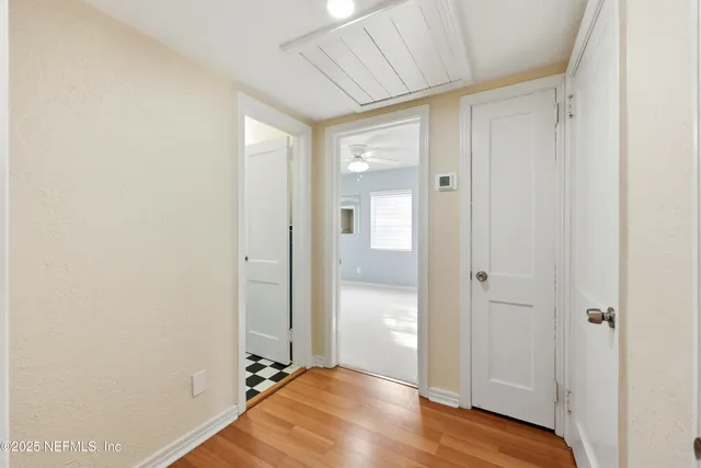 an empty room with windows and ceiling fan