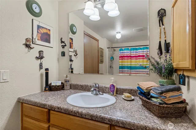 a bathroom with a granite countertop sink a mirror and a shower