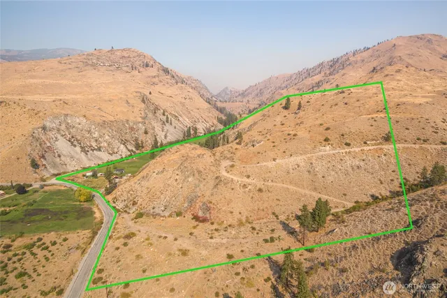 a view of a dry yard with wooden fence