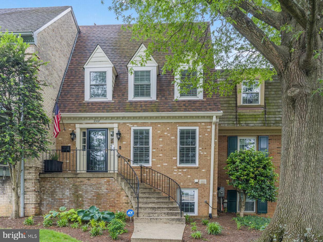 a front view of a house with a yard and potted plants